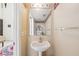 Cozy bathroom with pedestal sink and decorative wallpaper border at 3411 Landover Blvd, Spring Hill, FL 34609