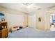 Neutral bedroom featuring ceiling fan, double closet, and small TV at 3411 Landover Blvd, Spring Hill, FL 34609