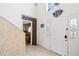 Bright entryway with tile flooring, white door with glass inserts, and staircase access at 3411 Landover Blvd, Spring Hill, FL 34609