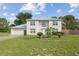 Two-story stucco home featuring a light metal roof, attached garage and manicured lawn at 3411 Landover Blvd, Spring Hill, FL 34609