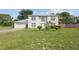 Charming two-story house with a well-manicured lawn, complemented by lush greenery and an American flag at 3411 Landover Blvd, Spring Hill, FL 34609