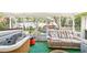 Enclosed patio area featuring a jacuzzi, outdoor seating, and green turf at 3411 Landover Blvd, Spring Hill, FL 34609