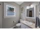 Bright bathroom featuring tile floors, toilet, and vanity with large mirror and overhead lighting at 4783 School Rd, Land O Lakes, FL 34638