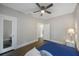 Bedroom features wood floors, lamp on nightstand and a door to an ensuite bathroom at 4783 School Rd, Land O Lakes, FL 34638