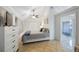 Bright bedroom featuring a ceiling fan, neutral walls, closet, dresser and an attached bathroom at 4783 School Rd, Land O Lakes, FL 34638