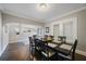 Elegant dining room with dark wood table set for six, hardwood floors, and an archway leading to the living area at 4783 School Rd, Land O Lakes, FL 34638