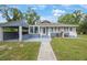 Inviting single-story home with a covered carport, light blue exterior, and well-manicured front lawn at 4783 School Rd, Land O Lakes, FL 34638