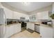 Efficient kitchen featuring white cabinets, stainless steel appliances and a window view at 4783 School Rd, Land O Lakes, FL 34638