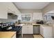 Practical kitchen with ample countertop space, stainless dishwasher, and bright lighting at 4783 School Rd, Land O Lakes, FL 34638