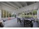 Spacious sunroom featuring white beams, screened windows, and comfortable seating area at 4783 School Rd, Land O Lakes, FL 34638