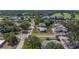 An aerial view of a quiet suburban neighborhood with mature trees, a golf course, and a lake at 501 Poinsettia Rd, Belleair, FL 33756