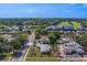 An aerial view of a quiet suburban neighborhood with mature trees, a golf course, and a lake at 501 Poinsettia Rd, Belleair, FL 33756