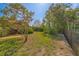 Spacious, grassy backyard featuring beautiful landscaping, mature trees, and a privacy fence at 501 Poinsettia Rd, Belleair, FL 33756