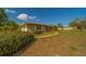 A well-maintained single-story home featuring lush landscaping and a sidewalk leading to the front door at 501 Poinsettia Rd, Belleair, FL 33756