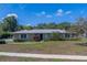 Charming single-story home featuring manicured lawn, mature trees, and well-maintained landscaping at 501 Poinsettia Rd, Belleair, FL 33756