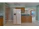 Spacious kitchen includes stainless refrigerator, wooden cabinets, and tile flooring at 501 Poinsettia Rd, Belleair, FL 33756