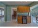 Kitchen with view to formal dining, wooden cabinets, tile flooring, and a beverage cooler at 501 Poinsettia Rd, Belleair, FL 33756
