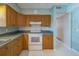 Bright kitchen with white appliances, wooden cabinetry, and a view to another room at 501 Poinsettia Rd, Belleair, FL 33756