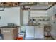 Functional laundry area includes a utility sink, washer, dryer, water heater and storage shelving at 501 Poinsettia Rd, Belleair, FL 33756