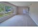 Expansive living room with carpet, large picture window with lush landscape views at 501 Poinsettia Rd, Belleair, FL 33756
