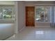 Bright and airy living room with white tile floor, large windows offering natural light, and neutral decor at 501 Poinsettia Rd, Belleair, FL 33756