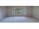 Spacious living room featuring carpet floors, neutral paint, and bright natural lighting at 501 Poinsettia Rd, Belleair, FL 33756