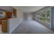 Open-concept living room with carpet and a large window overlooking the outside greenery at 501 Poinsettia Rd, Belleair, FL 33756