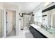 Bathroom featuring double sinks, sleek black and white accents, and a glass-enclosed shower at 504 Cleveland Ave, Largo, FL 33770