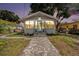 Inviting home exterior at dusk with paver walkway, manicured lawn, and stylish front door at 504 Cleveland Ave, Largo, FL 33770