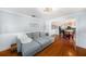 Inviting living room with a comfortable gray sofa, hardwood floors, and a seamless flow to the dining area at 504 Cleveland Ave, Largo, FL 33770