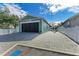 View of new construction garage with paved driveway, and light blue facade at 613 6Th E Ave, Bradenton, FL 34208