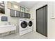 Garage featuring a utility sink, side-by-side washer and dryer and large screen television at 613 6Th E Ave, Bradenton, FL 34208