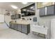 Well-organized garage with custom cabinets, sink, large screen TV, and epoxy flooring at 613 6Th E Ave, Bradenton, FL 34208