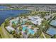 Aerial view of community pool with slides, lap pool and clubhouse, all nestled beside a serene lake at 6227 Golden Nettle Dr, Apollo Beach, FL 33572