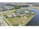 Wide aerial shot of a community featuring a community center, tennis courts, and green spaces near residential homes at 6227 Golden Nettle Dr, Apollo Beach, FL 33572