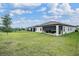 View of home's backyard featuring covered patio and lush green lawn at 6227 Golden Nettle Dr, Apollo Beach, FL 33572