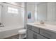 Bright bathroom with shower and bath combo, gray cabinets, and granite countertop at 6227 Golden Nettle Dr, Apollo Beach, FL 33572