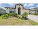 Attractive home featuring lush landscaping, an arched entrance, and a convenient two-car garage at 6227 Golden Nettle Dr, Apollo Beach, FL 33572