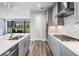 Modern kitchen with stainless steel appliances, sleek countertops, and gray wood floors at 6227 Golden Nettle Dr, Apollo Beach, FL 33572