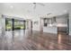 Open-concept living area with view of the kitchen, wood floors, and natural light at 6227 Golden Nettle Dr, Apollo Beach, FL 33572