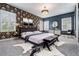 A main bedroom with a decorative accent wall, chandelier, mirrors, bench, and lots of natural light at 6227 Golden Nettle Dr, Apollo Beach, FL 33572