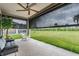 Covered patio featuring a ceiling fan and roll down shades with a view of the green lawn at 6227 Golden Nettle Dr, Apollo Beach, FL 33572