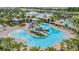 Aerial view of community pool area with waterslides, lounge chairs and umbrellas surrounded by lush palm trees at 6227 Golden Nettle Dr, Apollo Beach, FL 33572
