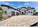 Stunning exterior elevation showcasing a large home, three-car garage and beautiful paver driveway at 6526 Surfside Blvd, Apollo Beach, FL 33572