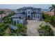 An eye-level view of a luxurious waterfront home featuring manicured landscaping, a spacious driveway, and stunning architectural details at 6526 Surfside Blvd, Apollo Beach, FL 33572