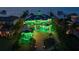 Stunning waterfront home featuring lush tropical landscaping, a sprawling layout, and vibrant green accent lighting at 6526 Surfside Blvd, Apollo Beach, FL 33572