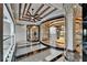 Modern hallway features glass elevator and view of large foyer chandelier at 6526 Surfside Blvd, Apollo Beach, FL 33572