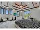 A modern, luxurious main bedroom featuring a unique tray ceiling, chandelier, and balcony access at 6526 Surfside Blvd, Apollo Beach, FL 33572