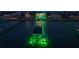 Stunning waterfront property with private dock and boat lift, enhanced by vibrant green accent lighting at 6526 Surfside Blvd, Apollo Beach, FL 33572
