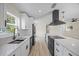 Bright kitchen with stainless steel appliances, marble countertops, and stylish black range hood at 6816 S Hesperides St, Tampa, FL 33616